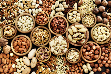 Colorful mix of various nuts: peanut and cashew, hazelnut and almond, pine nuts and walnut; healthy...