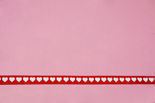 Red Gross Grain Ribbon with White Hearts Accross Bottom of Pink Background