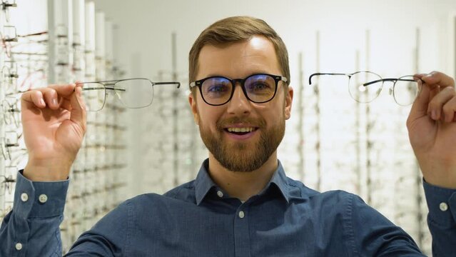 Health care, eyesight and vision concept - happy man choosing glasses at optics store