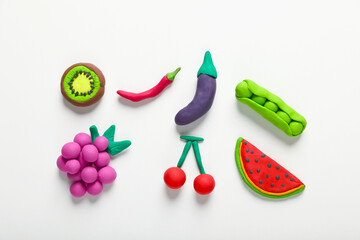 Different colorful fruits and vegetables made from plasticine on white background, top view