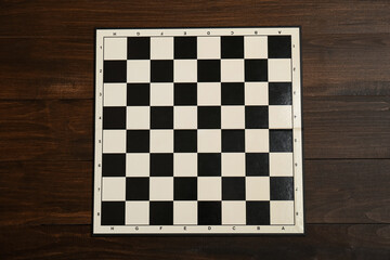 Game checkerboard on wooden table, top view