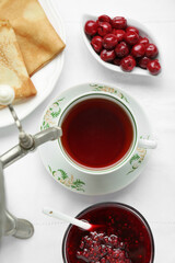 Cup of aromatic tea and treats on table, flat lay