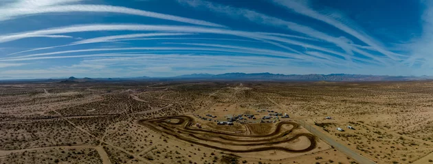 Schilderijen op glas Panoramic overhead view of dirt motorcycle track in barren desert landscape in the Mojave desert © FroZone
