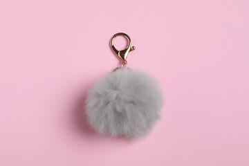 Gray fur keychain on pale pink background, top view