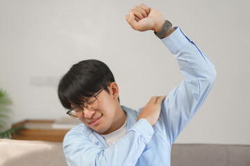 Business lifestyle, Businessman raising arm while exhausted and shoulders pain from office syndrome