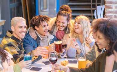 Group of happy friends are drinking beer and cocktail together . Young people student multiracial toast smiling with wine in lifestyle friendship in a pub party