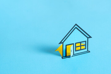 Paper house on blank blue background