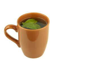 Closeup of a cup of hot coca tea with coca leaves on white background. Concept of natural and...