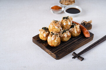 Takoyaki is Japanese Street Food containing with octopus, sausage or cheese. garnish with seaweed and katsuobushi