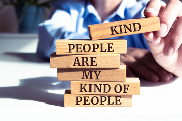 Close up on businessman holding a wooden block with "Kind people are my kind of people" message