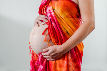 pregnant woman touching her bump in the latest stage of pregnancy, mid-section showing the belly...