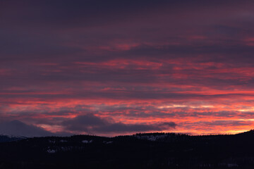 Obraz premium Incredible sunset views in winter season from northern Canada with bright pink clouds, mountains and snow at dusk.