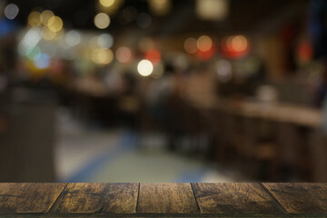 Empty dark wooden table in front of abstract blurred boken bankground of restaurant. Can used for display or montage your products. Mock up for space.