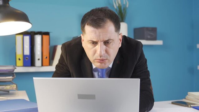 Businessman looking at computer in office.
The businessman is seriously working from the computer.
