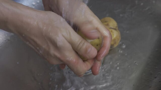 man hands wash potatoes in the sink lifestyle