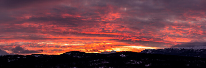 Incredible sunset views in winter season from northern Canada with bright pink clouds, mountains and snow at dusk.