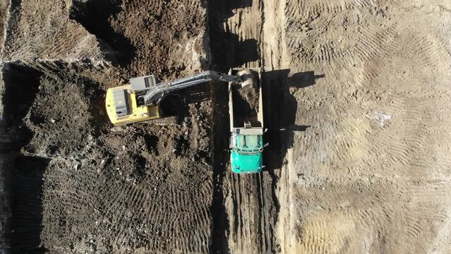 Excavadora cargando un cami&oacute;n en una construcci&oacute;n
