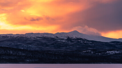 Incredible sunset views in winter season from northern Canada with bright pink clouds, mountains and snow at dusk.