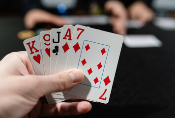 A closeup image of a poker hand of cards at a gambling table