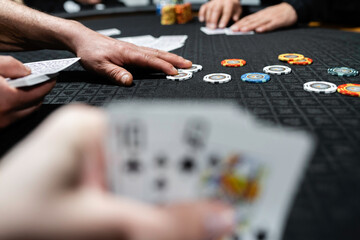 A scene of people playing a card game with poker chips scattered over the gambling table