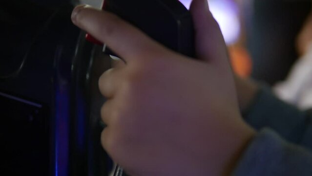 Close-up of a kid's hands playing games at the arcade.