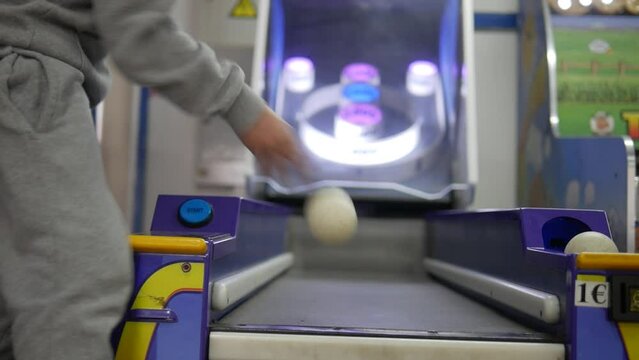 A child playing Skee Ball at an arcade. Low angle point of view.