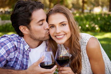 Couple portrait, wine or cheek kiss on picnic date, valentines day or romance bonding in nature, park or garden. Smile, happy woman and man with alcohol drinks glass for love anniversary celebration