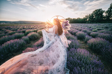Beautiful bride in a lavender field at sunset. The concept of a wedding in nature.