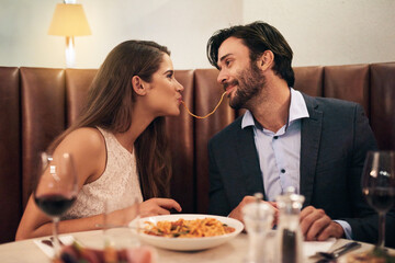 Love, happy and spaghetti with couple in restaurant sharing for romance, valentines day and date. Bonding, smile and celebration with man and woman with pasta at table for fine dining, wine and cute