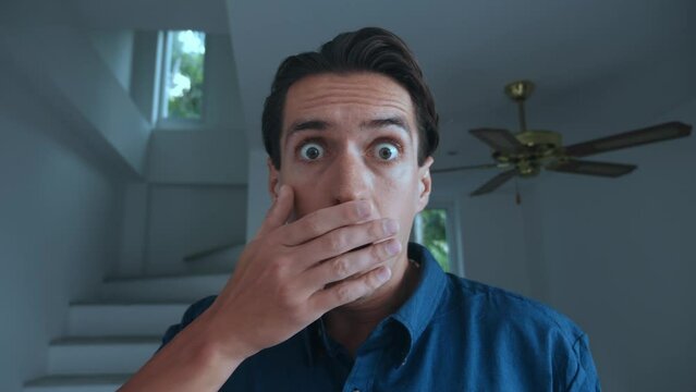 Scared man takes off his glasses and is frightened by what he sees. Portrait of scared young 30 millennial man. Business man takes off glasses in fright and covers his mouth, scared by bad news