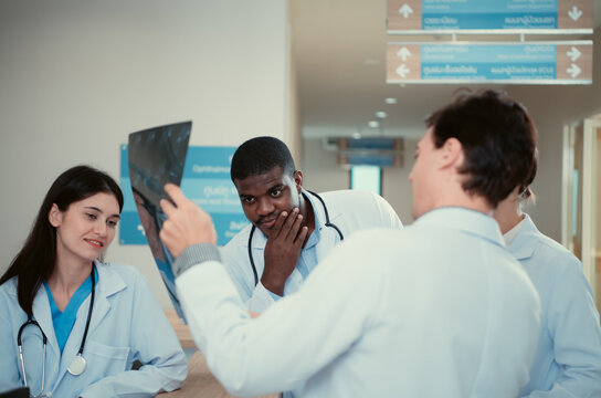 Medical teacher and interns analyzing the x-ray results of the patient's brain. before major surgery in the operating room