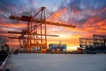 Obraz premium Crane loading cargo container freight container ship in the international terminal logistics sea port concept freight shipping by ship, Truck running in port under the Big Crane transport.