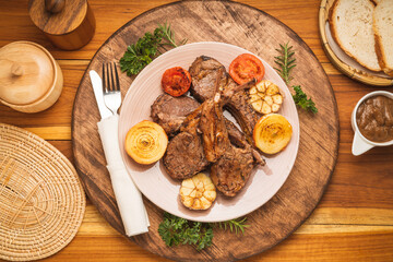 Lamp Rack Steak or Lamb chops Steak with rosemary, onion and tomato on wooden background. 