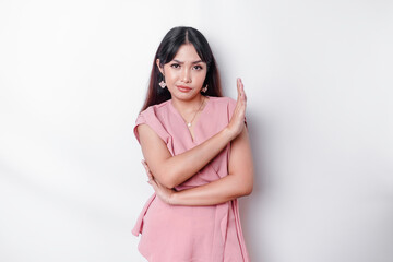 Beautiful Asian woman wearing pink blouse with hand gesture pose rejection or prohibition with copy...
