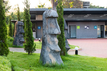 Moai statues on green grass.