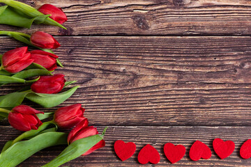 Row of tulips on wooden background with space for message. Background for Mother's Day, Valentine's Day.