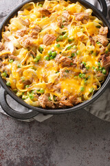 Tuna Pasta Baked with green Peas and mushrooms closeup on the pan on the table. Vertical top view from above