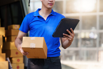 Asian courier with parcel and delivery logistic concept. Delivery man using digital tablet
