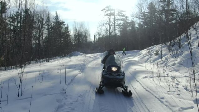 a group of snowmobilers and a snow bike moto. Aerial view of a snowmobile that rides in the middle of a fabulous snowy forest. sport event. Winter fun moto extreme. 4K ProRes 422 HQ