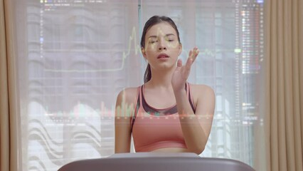 Attractive woman running on a treadmill at home and looking stock market and using hand sliding on the virtual monitor. - Powered by Adobe