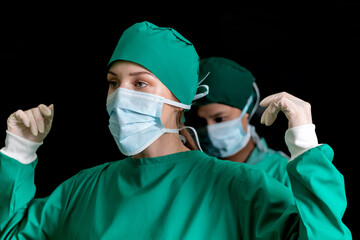 Fototapeta na wymiar nurse help surgeon wearing medical uniform to protect body in operation. surgical doctor preparing to perform operation got help by staff. professional surgical woman support doctor putting uniform