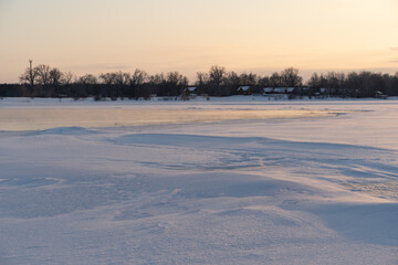 Winter sunset on the big river, hummocks in the rays of the sun.