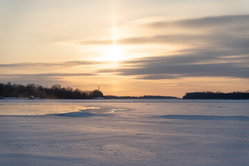 Winter sunset on the big river, hummocks in the rays of the sun.
