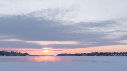 Fototapeta na wymiar Winter sunset on the big river, hummocks in the rays of the sun.