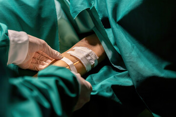 doctor putting medical tape tube patient for infusion operation. expert surgeon performing stick tape to attach tube. professional surgery staff attach iv bag cord to person arm with adhesive tape
