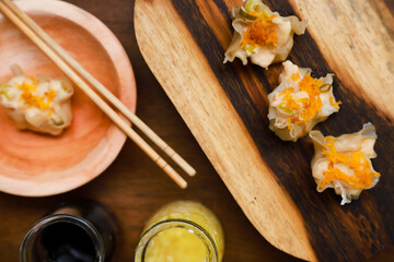 Flat lay of traditional chinese dimsum with sauce and herbs serve on a wooden table