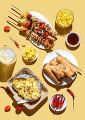 kebabs on skewers spring rolls and corn