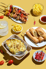 kebabs on skewers spring rolls and corn