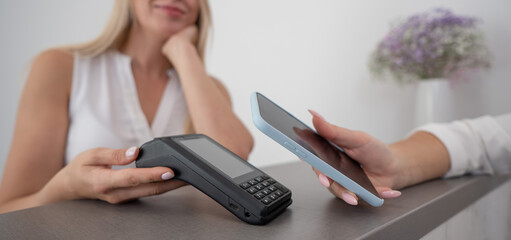 A woman pays using a non -contact payment of the NFC used by a smartphone. 