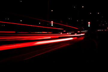 Lights of cars at night. Street line lights. Night highway city. Long exposure photograph night road. Colored bands of red light trails on the road. Background wallpaper defocused